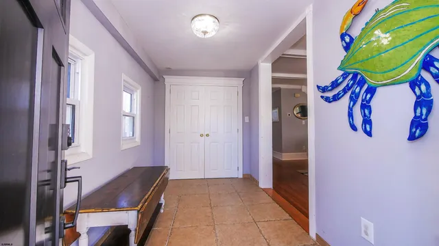 a hallway with painting on the wall and a window
