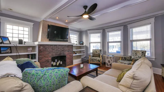 a living room with furniture a flat screen tv and a fireplace
