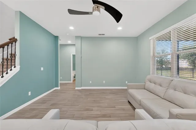 a living room with furniture and a ceiling fan