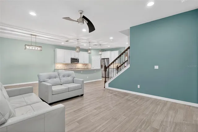 a living room with furniture and a ceiling fan