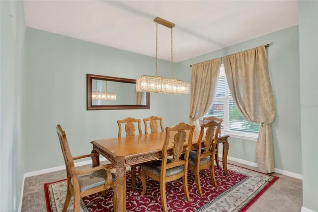 a dining room with furniture a chandelier and window