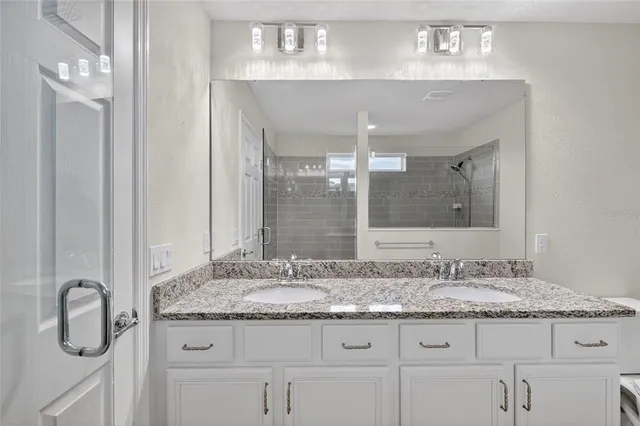 a bathroom with a granite countertop sink and a mirror