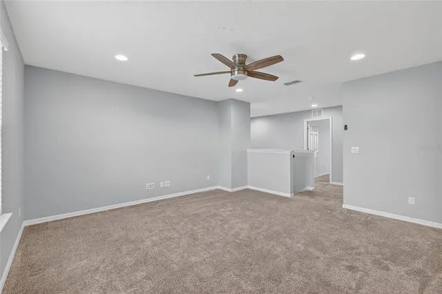 a view of an empty room with a ceiling fan