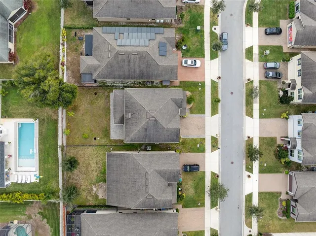 an aerial view of residential houses with outdoor space and parking