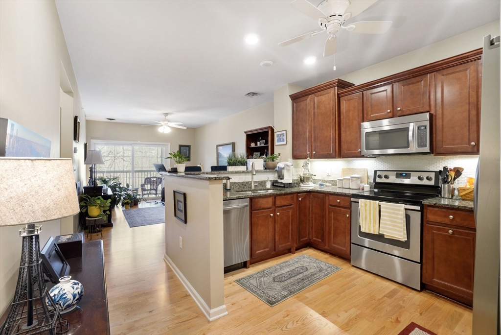 a kitchen with stainless steel appliances kitchen island granite countertop a refrigerator stove and sink