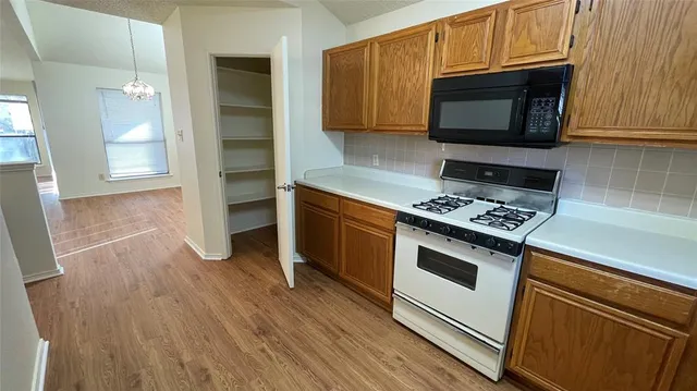 a kitchen with granite countertop wooden cabinets and a stove top oven