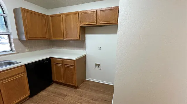 a kitchen with cabinets and wooden floor