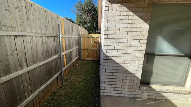 a view of a yard with wooden fence