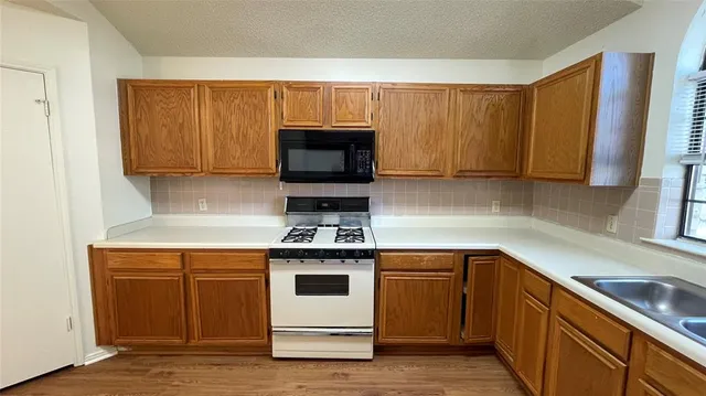 a kitchen with a sink stove and microwave