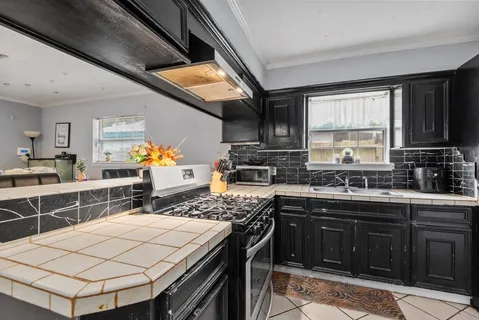 a kitchen with stainless steel appliances granite countertop a sink stove and cabinets