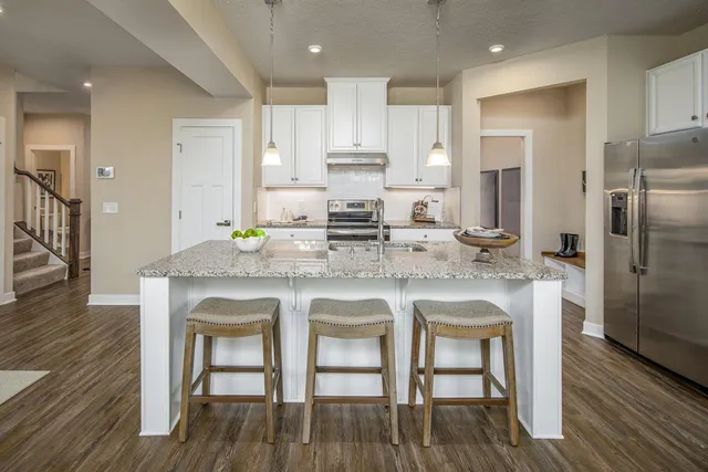a kitchen with granite countertop white cabinets and stainless steel appliances