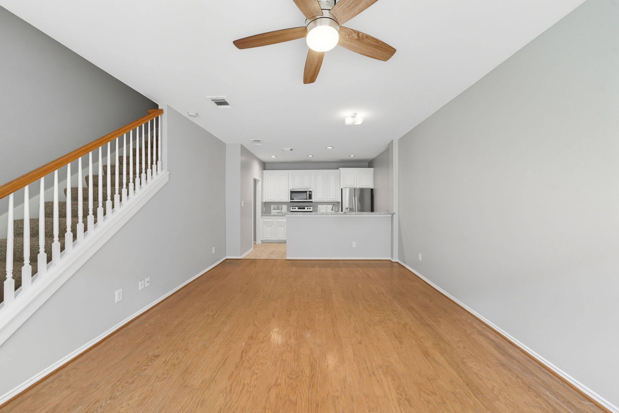 1507 Sutton Street Houston, TX 77006 - Photo 5 of 22 a view of a big room with wooden floor a ceiling fan and windows