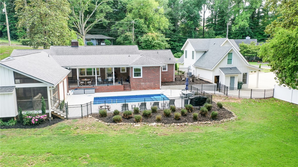 103 Riggs Drive Clemson, SC 29631 - Photo 48 of 50 An inviting backyard oasis offers a pristine swimming pool, expansive patio, and lush landscaping.