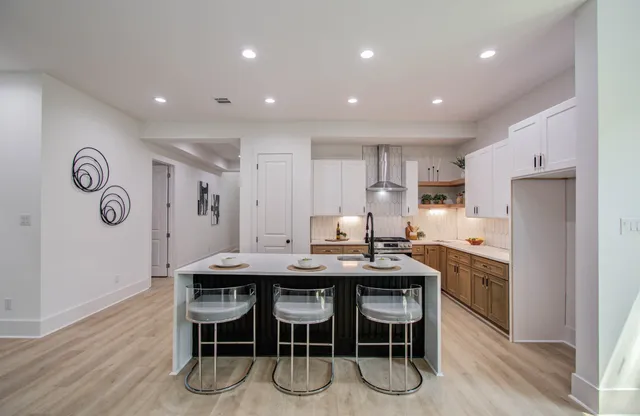 a kitchen with stainless steel appliances granite countertop a table chairs sink and cabinets
