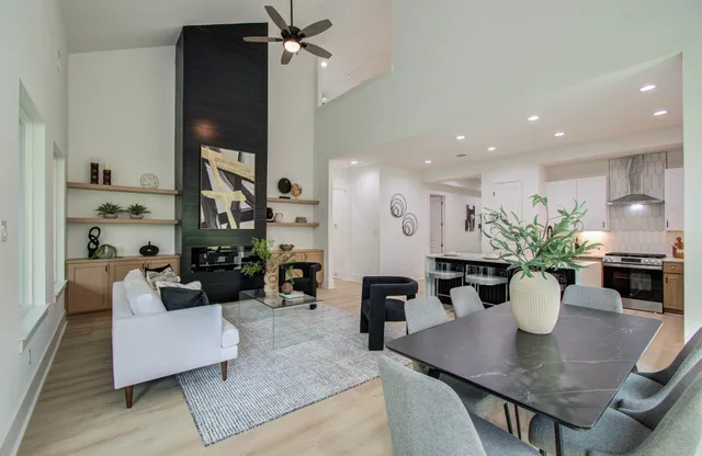 a view of a dining room and livingroom with furniture wooden floor a chandelier