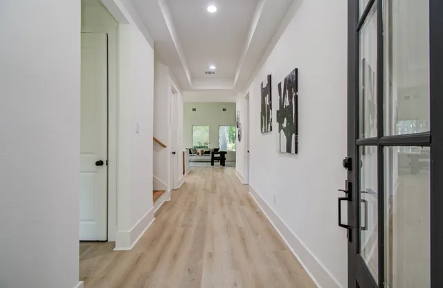 a view of a hallway with wooden floor and staircase