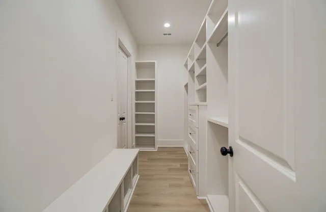 a view of a hallway with wooden floor and entryway