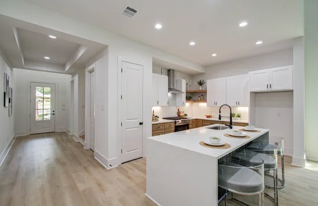a kitchen with a sink a stove and chairs