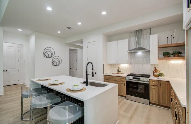 a kitchen with a sink a stove and chairs