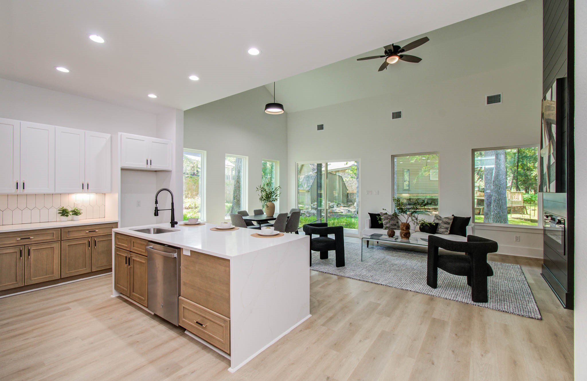 1802 Rollingwood Drive Huntsville, TX 77340 - Photo 8 of 38 a large kitchen with kitchen island a sink dishwasher a stove a dining table and chairs with wooden floor