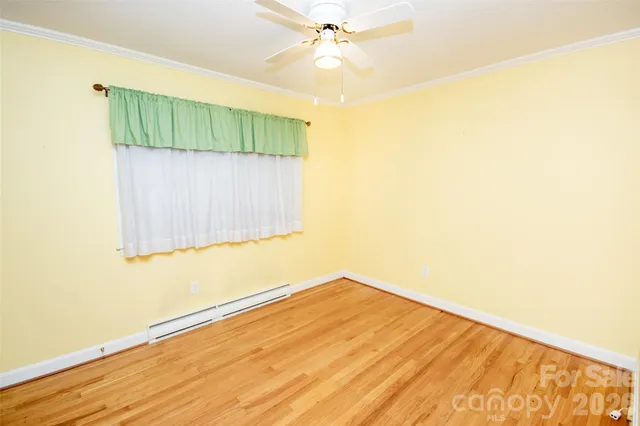 a view of a room with wooden floor and fan