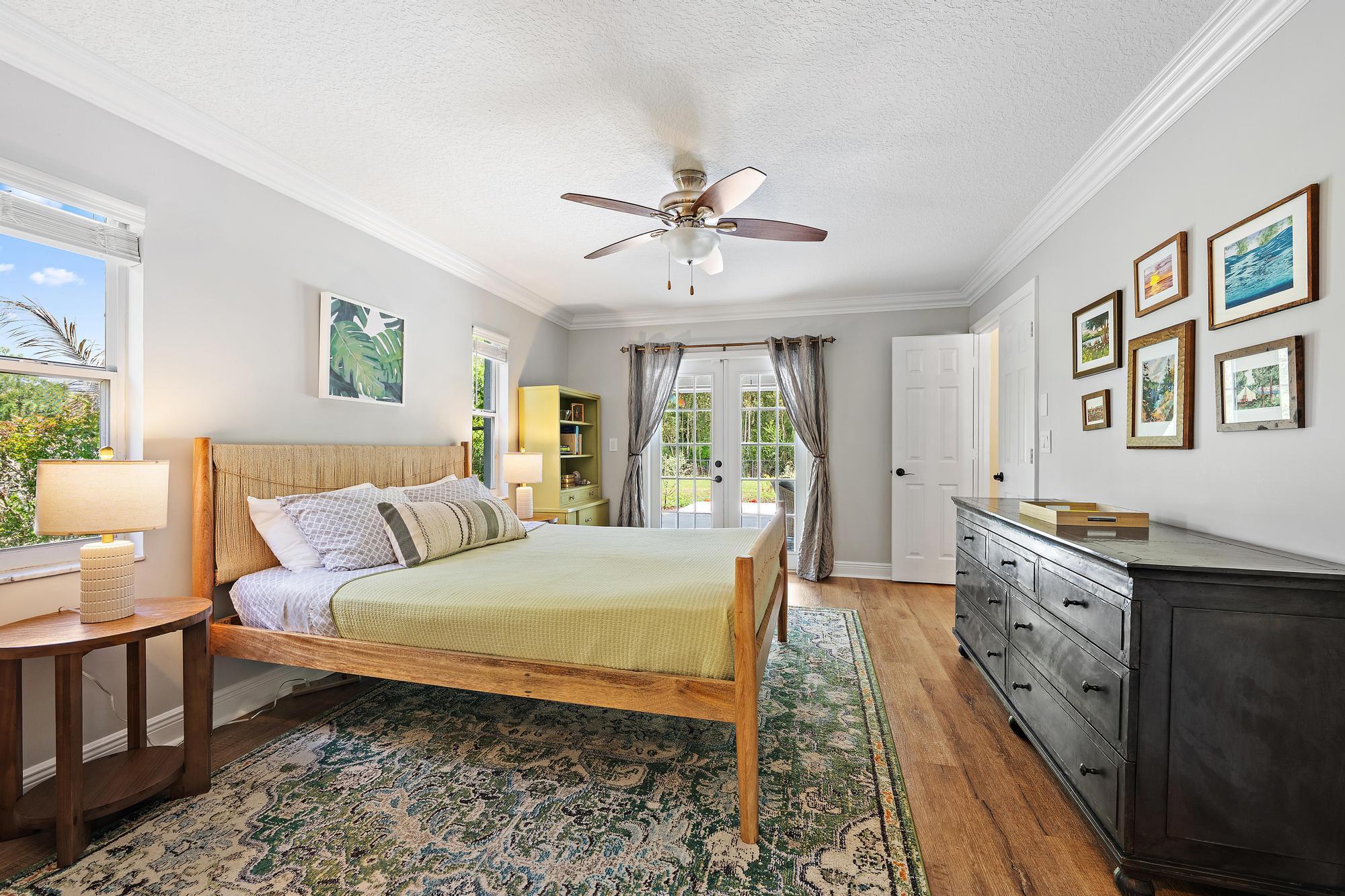 12177 86th Road North West Palm Beach, FL 33412 - Photo 15 of 40 a bedroom with a large bed and a chandelier