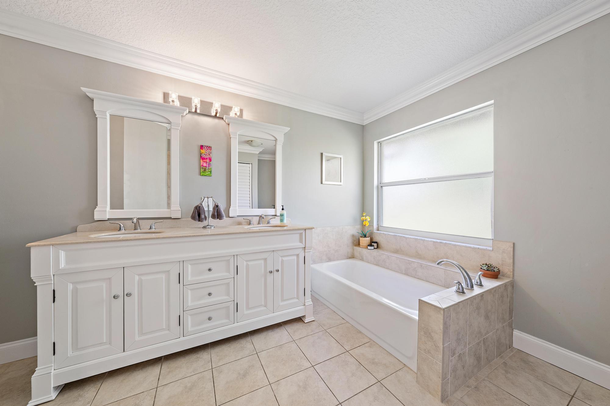 12177 86th Road North West Palm Beach, FL 33412 - Photo 18 of 40 a bathroom with a bathtub a double vanity sink and mirror