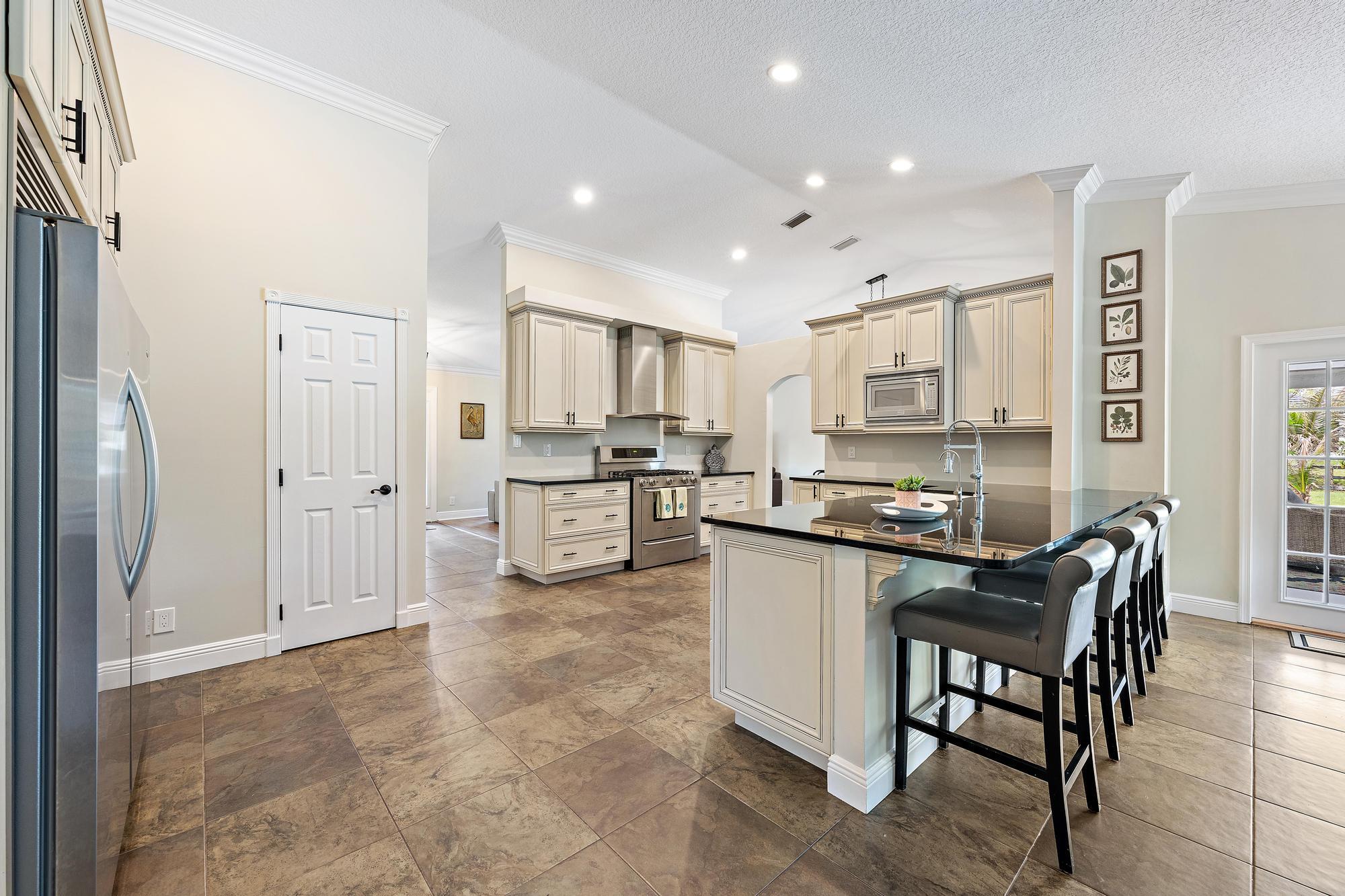 12177 86th Road North West Palm Beach, FL 33412 - Photo 26 of 40 a kitchen with white cabinets and stainless steel appliances