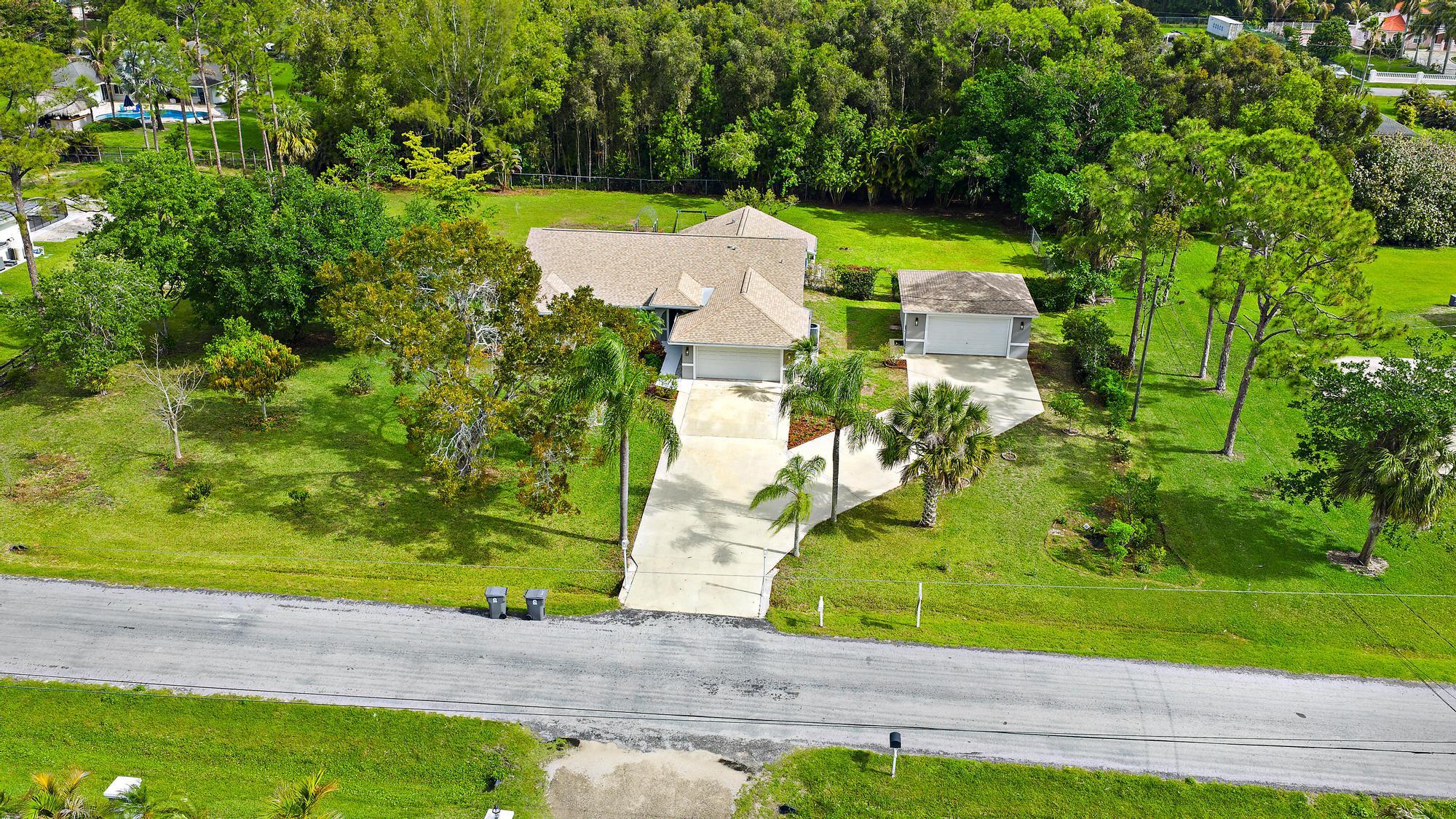 12177 86th Road North West Palm Beach, FL 33412 - Photo 31 of 40 an aerial view of a house with a yard and lake view