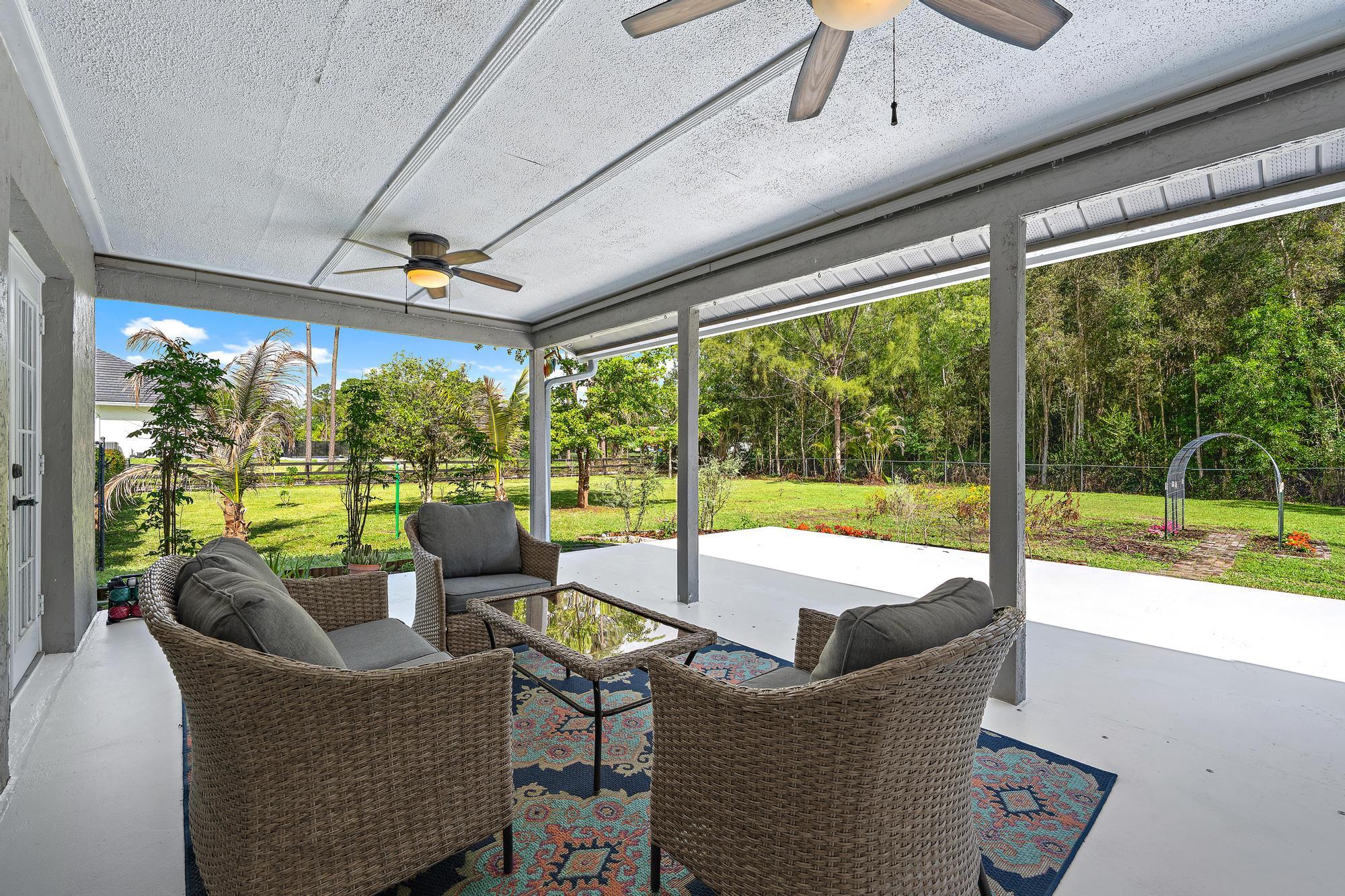 12177 86th Road North West Palm Beach, FL 33412 - Photo 5 of 40 a living room with couch and a floor to ceiling window
