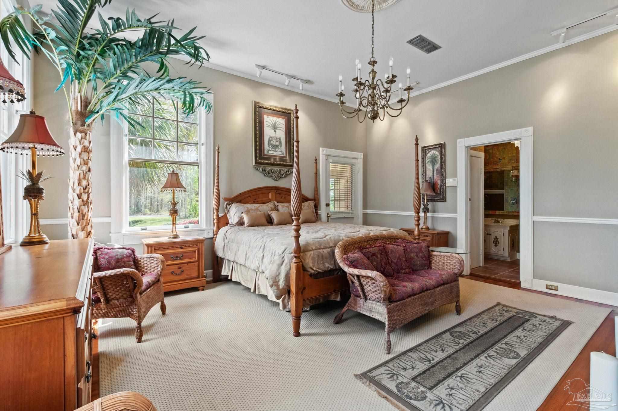 1701 Sowell Road Brewton, AL 36426 - Photo 48 of 72 a spacious bedroom with a bed and a chandelier