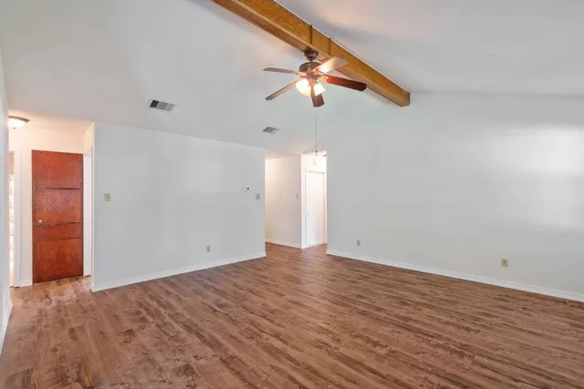 wooden floor fireplace and windows in an empty room