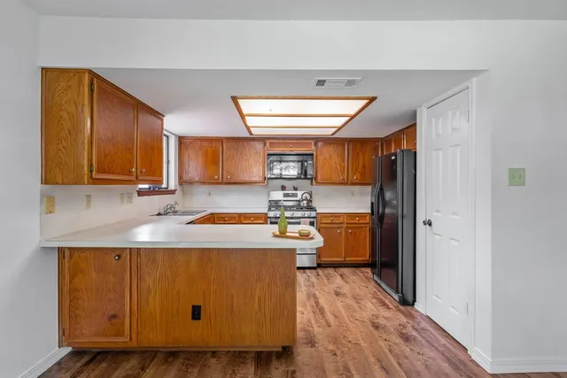 a kitchen with stainless steel appliances granite countertop a refrigerator stove top oven a sink and dishwasher