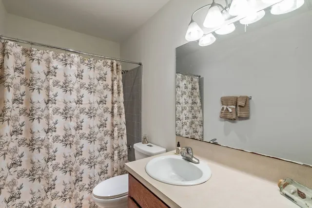 a bathroom with a sink a toilet and a mirror