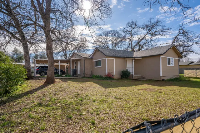 a view of a house with a yard covered with snow and trees