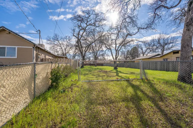 a view of yard with swimming pool and wooden fence