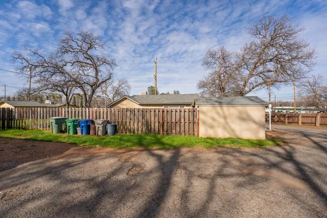 a view of a yard with wooden fence