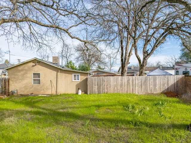 a white house that has a tree in front of it