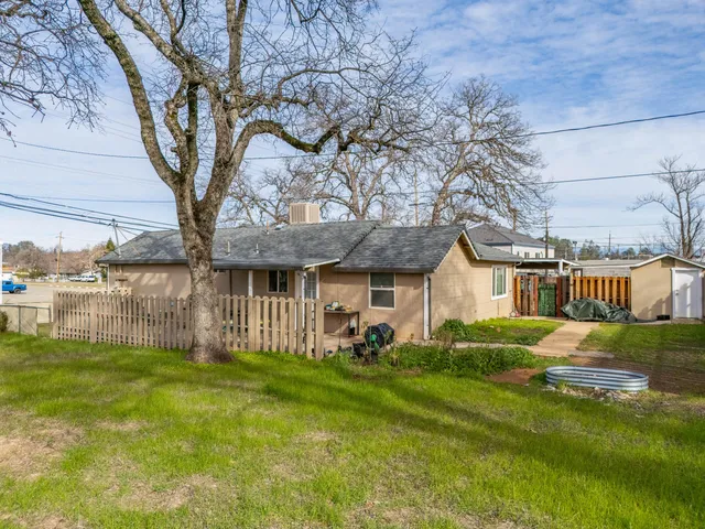 a backyard of a house with table and chairs