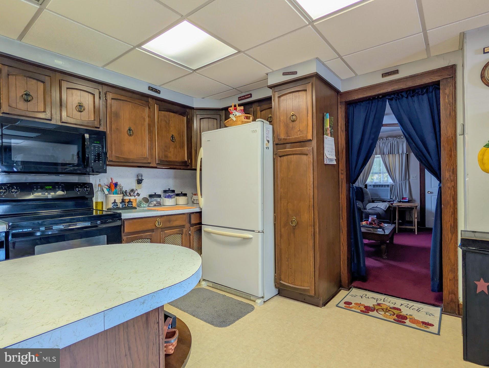 83 State Street Everett, PA 15537 - Photo 11 of 39 a kitchen with stainless steel appliances granite countertop a refrigerator a stove and a sink with wooden cabinets