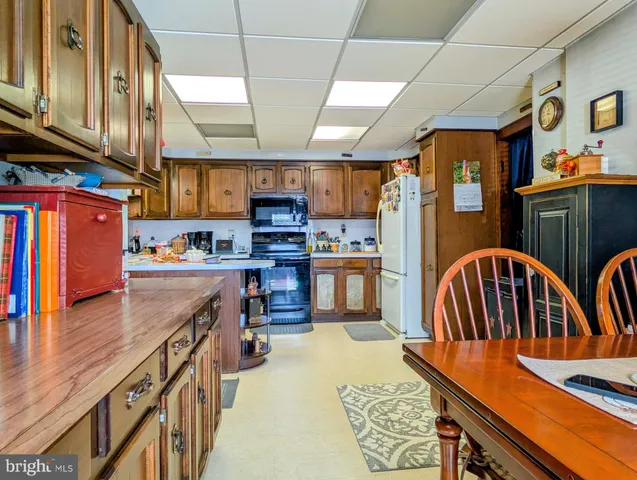a kitchen with stainless steel appliances kitchen island granite countertop a table chairs in it and wooden floors