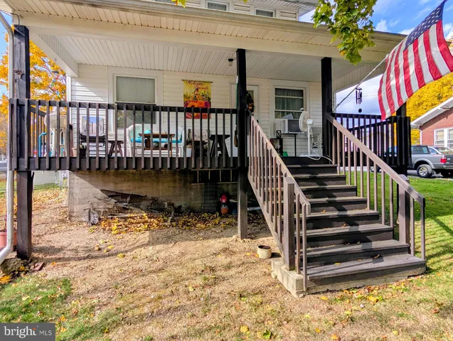 a view of a house with a yard and coconut trees