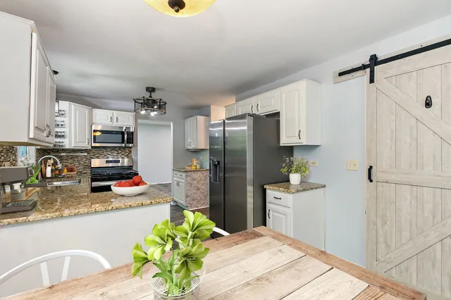 a kitchen with stainless steel appliances granite countertop a refrigerator and a sink