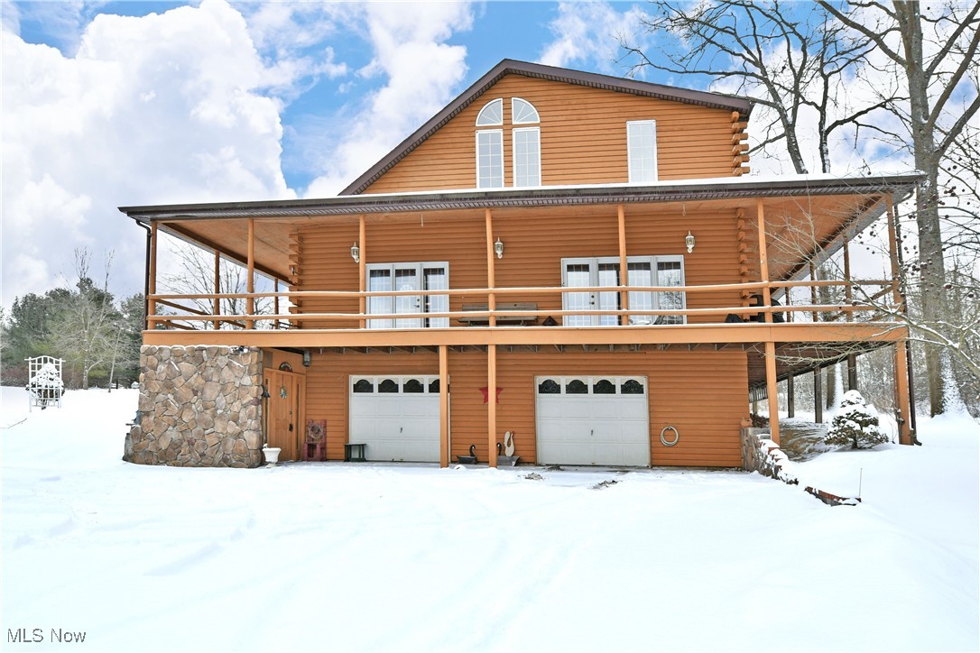 3339 Bushnell Campbell Road Fowler, OH 44418 - Photo 4 of 50 Snow covered property with a deck, log siding, and a garage