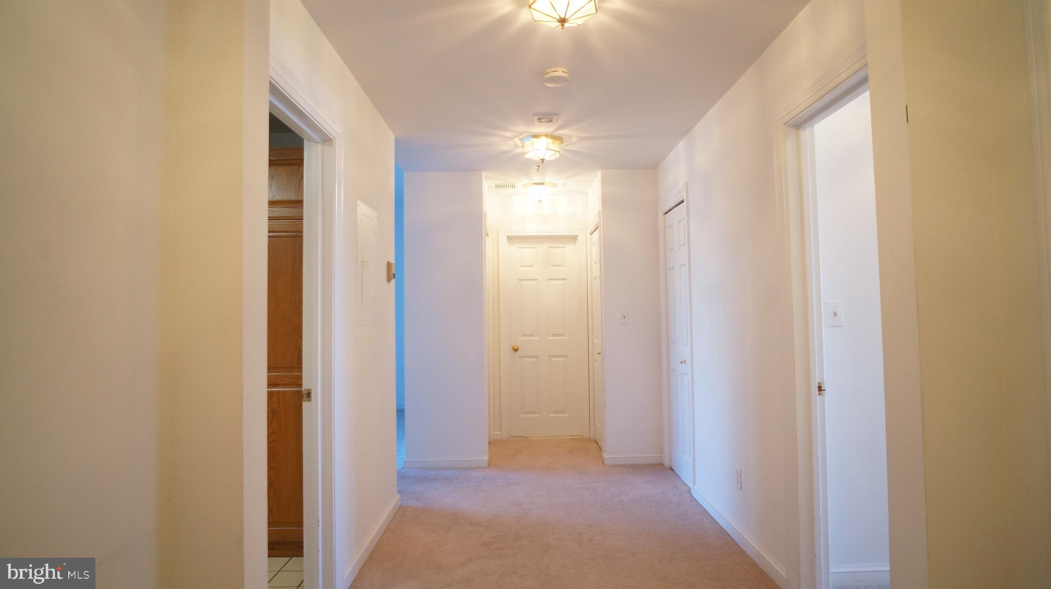 10 East Lee Street, Unit 705 Baltimore, MD 21202 - Photo 32 of 48 a view of a hallway with a chandelier fan and a bathroom