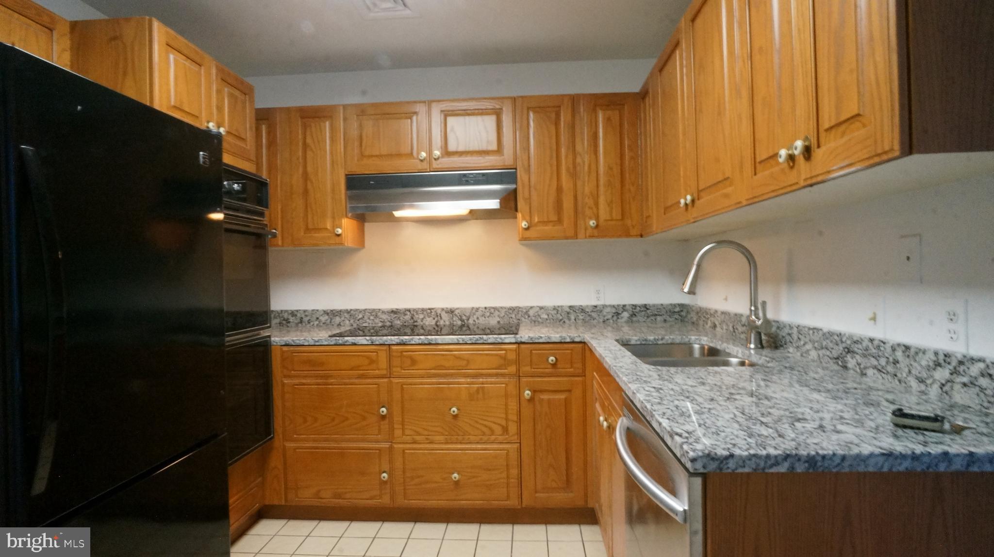 10 East Lee Street, Unit 705 Baltimore, MD 21202 - Photo 43 of 48 a kitchen with granite countertop a sink and cabinets