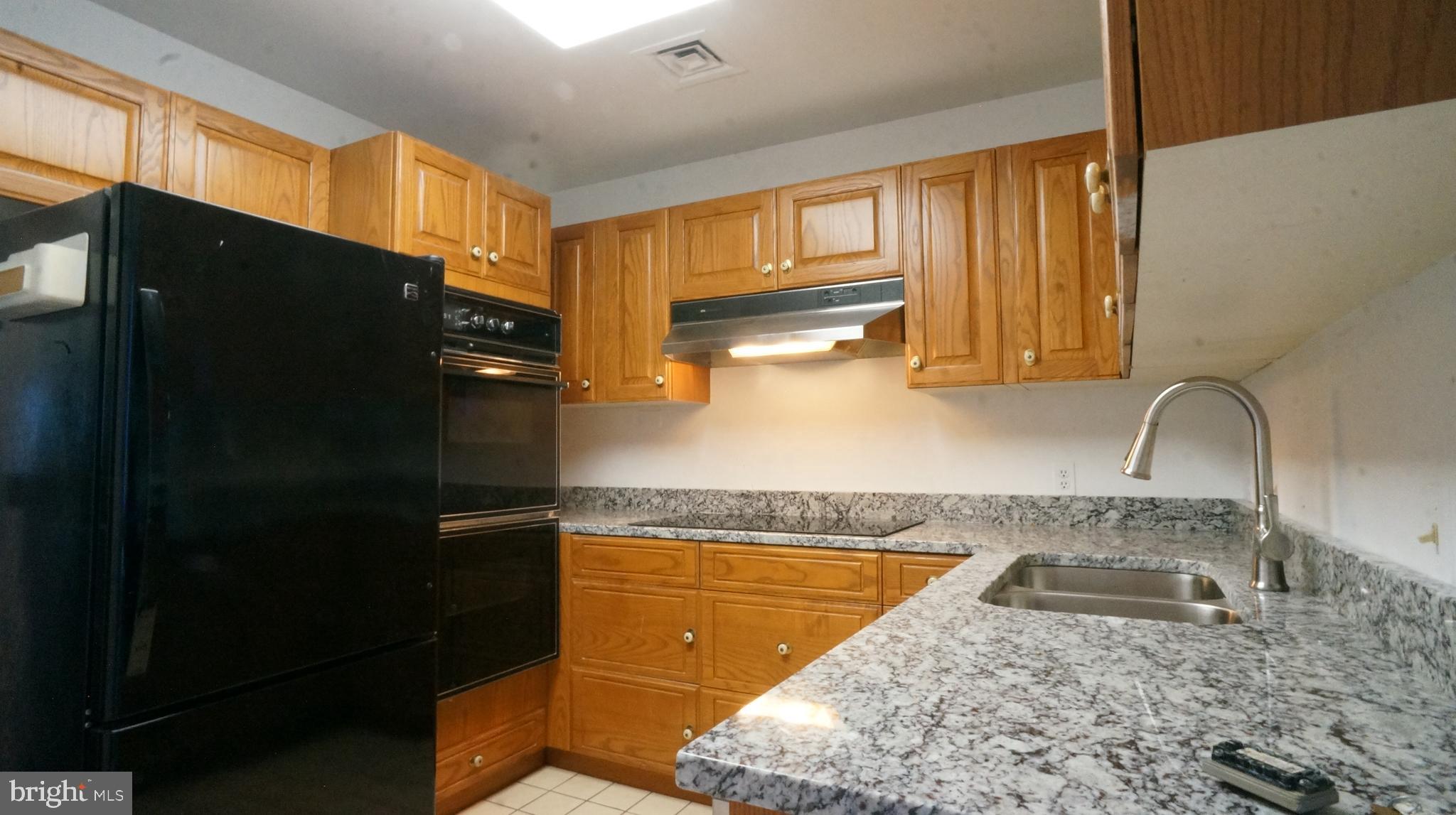 10 East Lee Street, Unit 705 Baltimore, MD 21202 - Photo 44 of 48 a kitchen with a sink a refrigerator and window