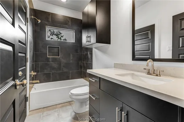 a bathroom with a granite countertop sink toilet and shower