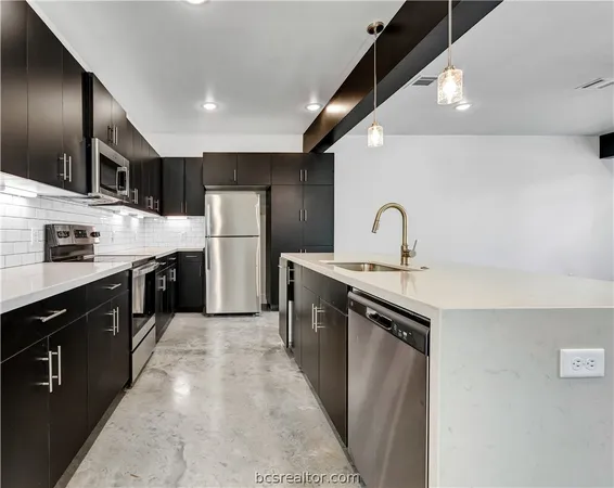 a kitchen with refrigerator a sink and cabinets