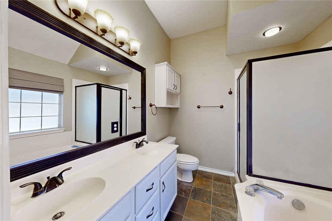 2817 Brandywine Circle Bryan, TX 77807 - Photo 18 of 28 a bathroom with a double vanity sink a toilet and a mirror